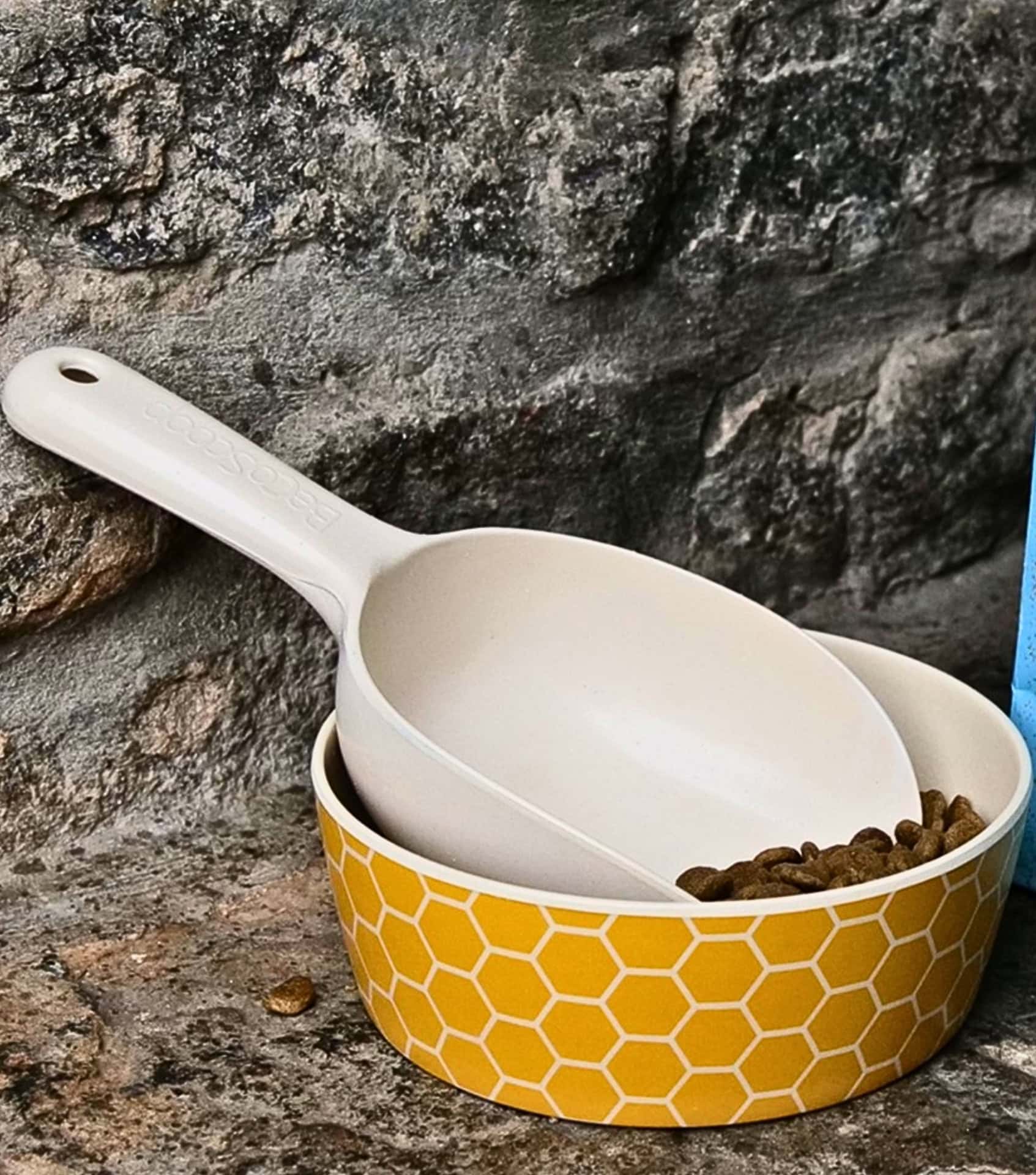 Sustainable yellow patterned dog bowl and biodegradable scoop made from bamboo fiber, ideal for eco-conscious pet owners.