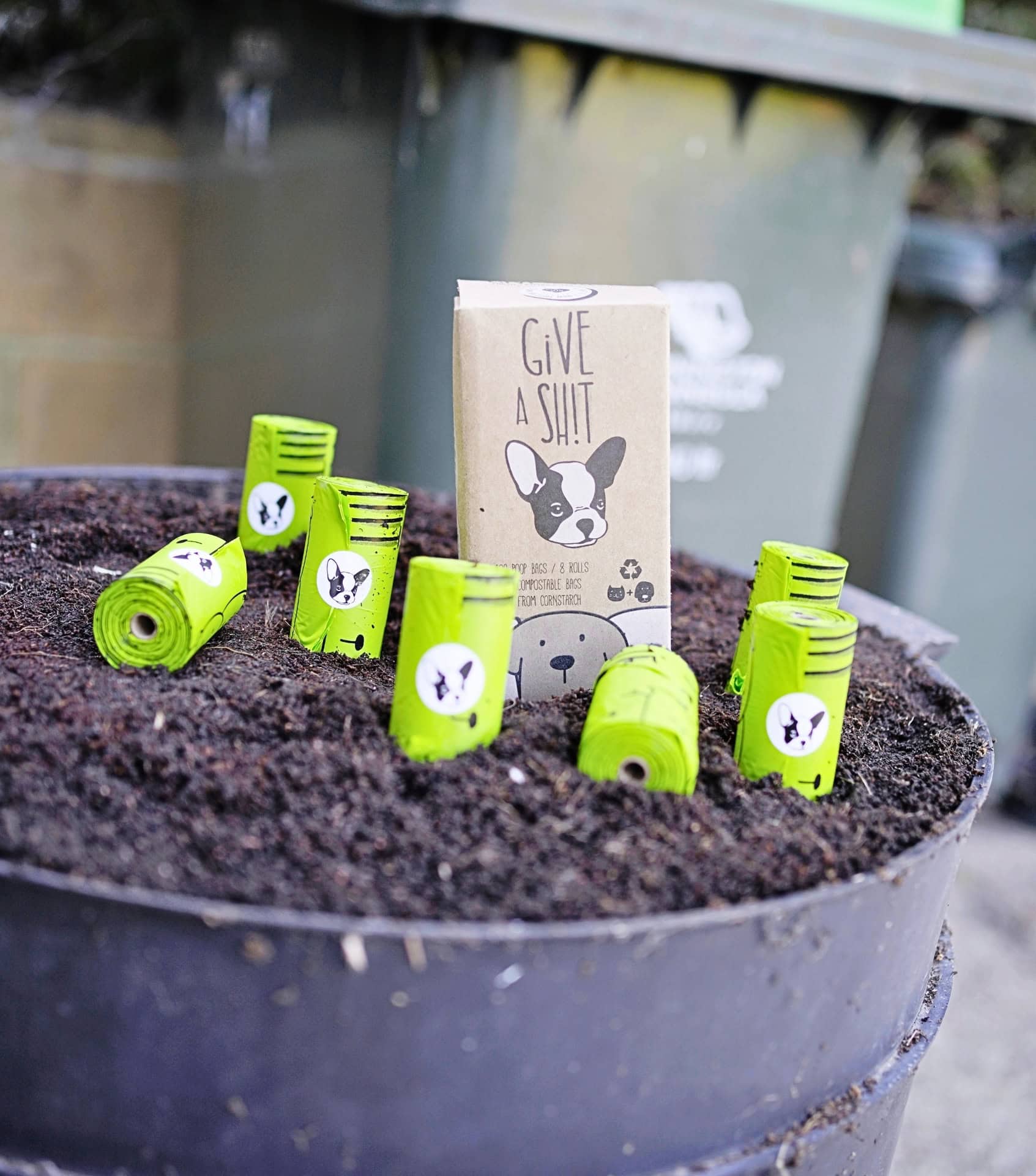 Give a Sh!t biodegradable dog poop bags displayed outdoors, highlighting sustainable pet products made for responsible waste disposal.