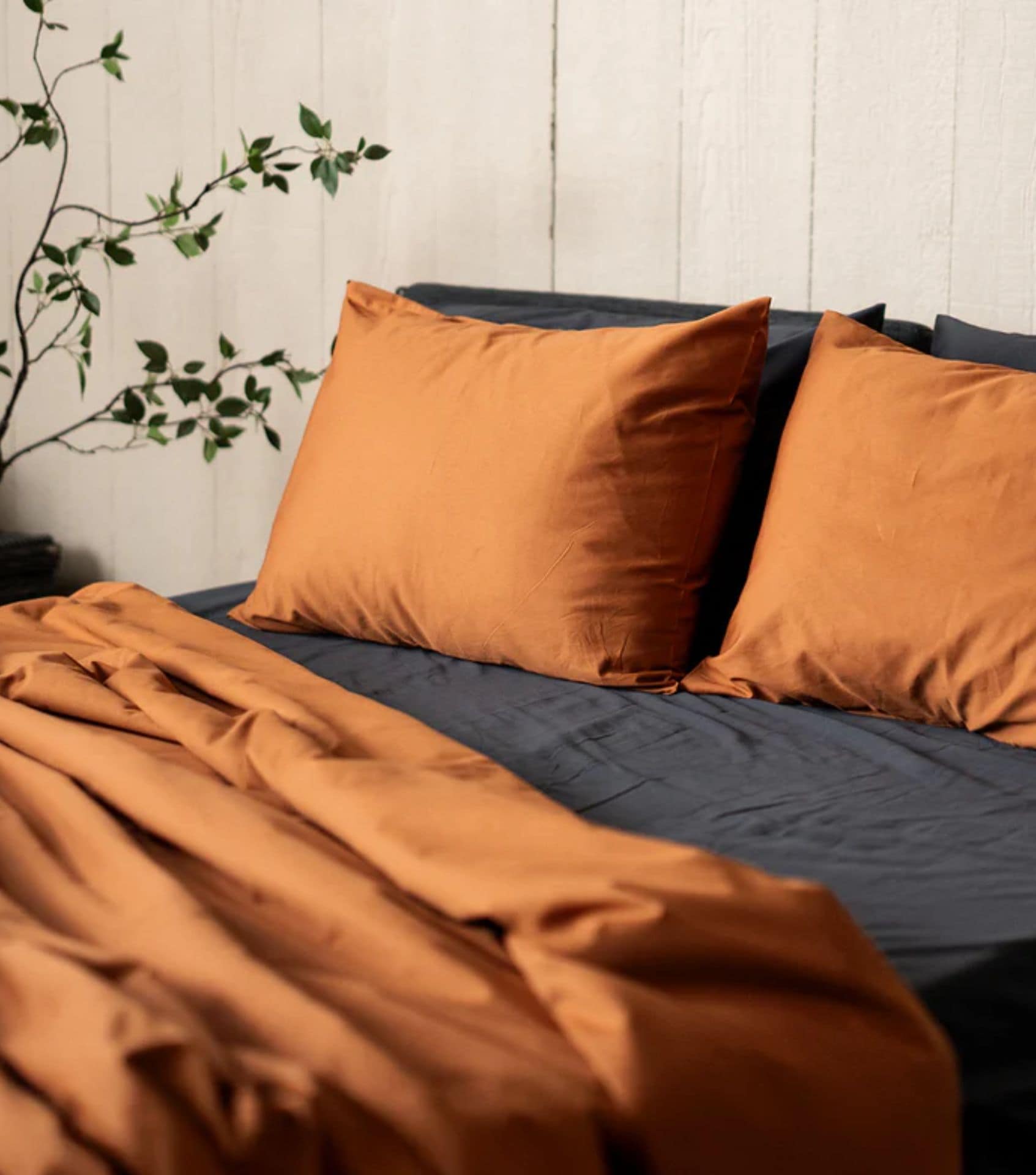 Nest Bedding is one of the Best Sustainable Bedding Brands - their terracotta sateen organic sheets are pictured