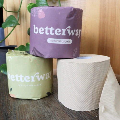 Betterway natural brown bamboo toilet paper rolls in purple and green wrappers alongside an unwrapped roll, photographed during Sustainable Jungle’s product testing for Sustainable Jungle's Betterway Rating.
