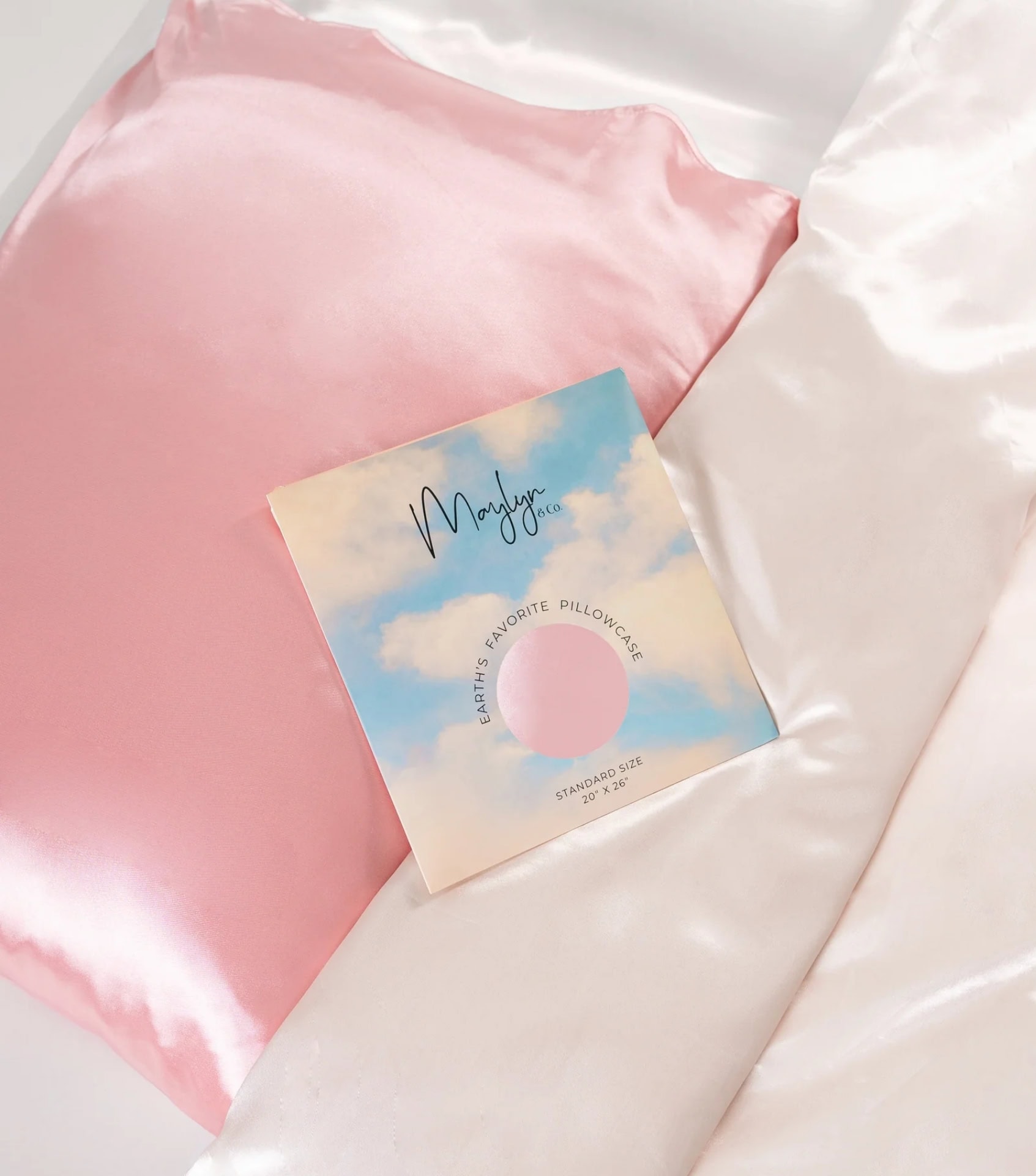 Sustainable vegan silk pillowcase by Maylyn and Co in blush pink with plastic-free packaging on white bedding