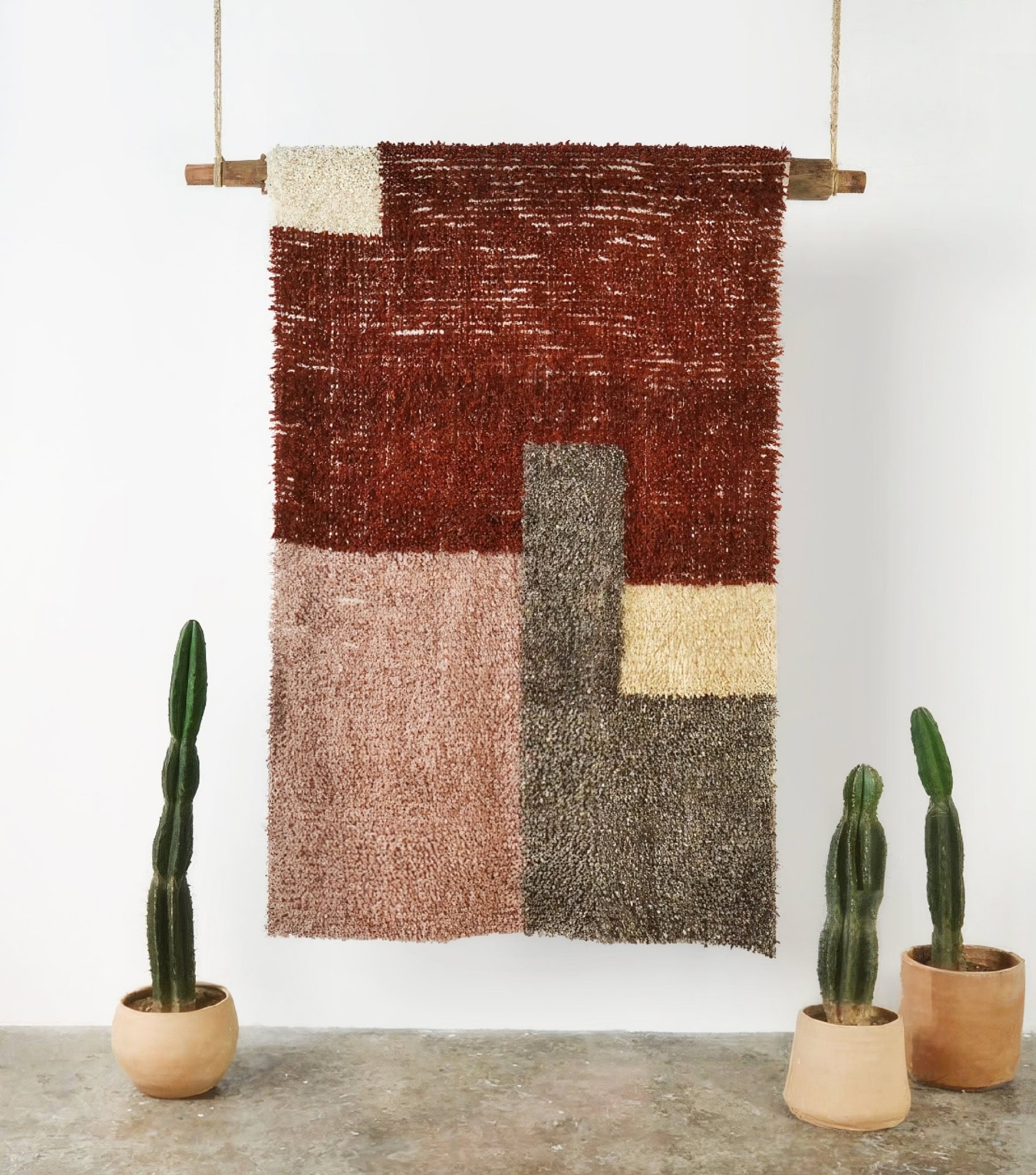 Best sustainable home goods featuring handwoven wall hanging in earth tones with geometric design