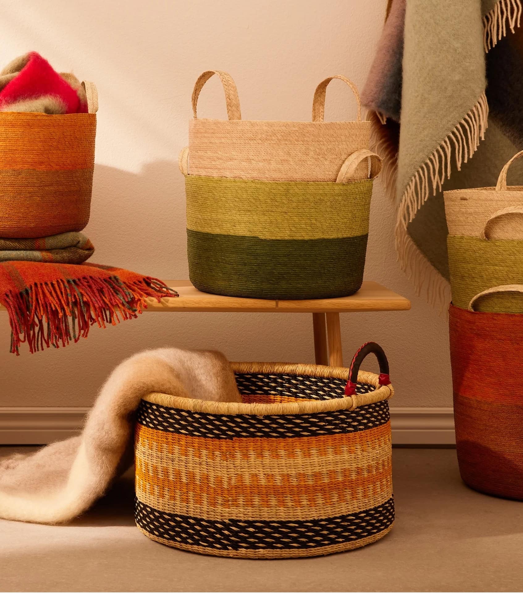 Sustainable homewares by Goodee featuring handwoven storage baskets and colorful throws