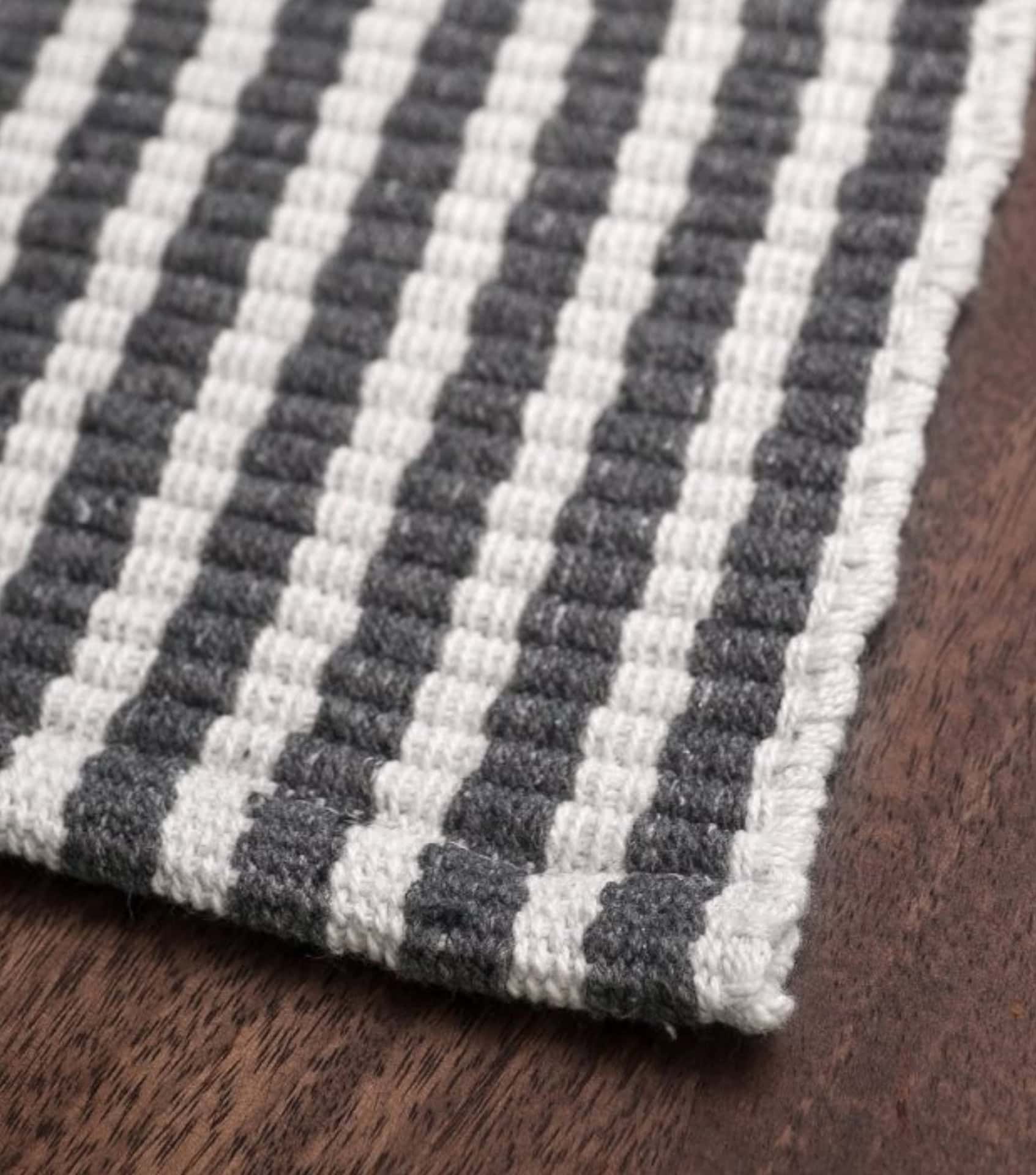 Sustainable home goods featuring handwoven striped rug in gray and white pattern